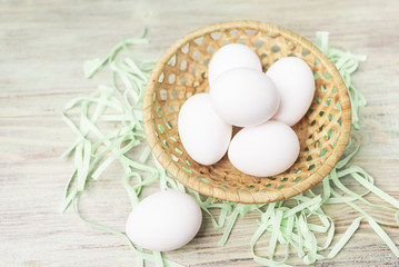 eggs in a wicker basket on a wooden background