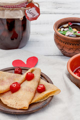 Ukrainian or Russian pancake blini with flavored cherry jam and herbal tea. Breakfast. Traditional...