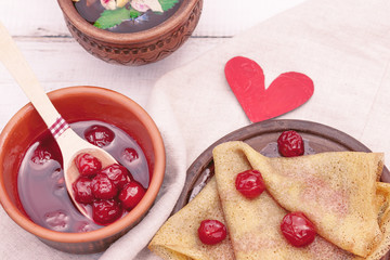 Ukrainian or Russian pancake blini with flavored cherry jam and herbal tea. Breakfast. Traditional dishes on the holiday Carnival Maslenitsa Shrovetide
