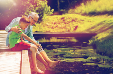 grandfather and grandson sitting on river berth