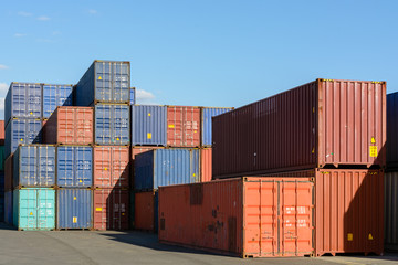 Dozens of dry cargo containers stacked in an intermodal port terminal.