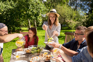 happy friends having dinner at summer garden party