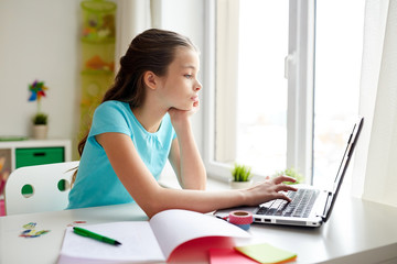 bored girl with laptop and notebook at home