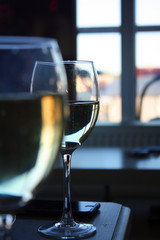 Two glasses of white wine standing on a table