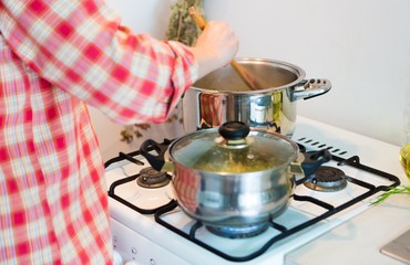 Woman mixing in pot with a wooden spoon