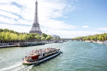 Selbstklebende Fototapete Paris Landschaftsblick auf den Eiffelturm und die Seine mit Touristenboot in Paris