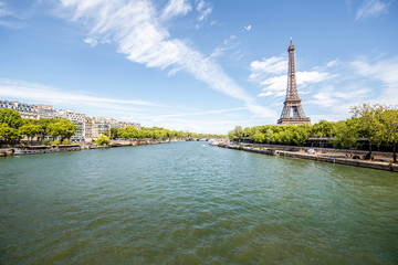 Obraz premium Krajobrazowy widok na wieżę Eiffla i Sekwanę w słoneczny dzień w Paryżu