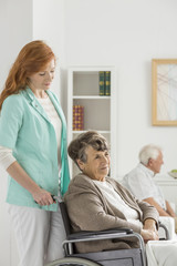 Fototapeta premium Assistant looks on elder woman