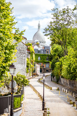 Obraz premium Pejzaż miejski widok na pięknej ulicie z Świętą Kierową katedrą na Monmartre wzgórzu w Paryż