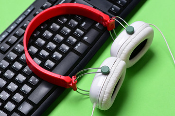 Obraz na płótnie Canvas Headphones and black keyboard. Earphones in red and white colors