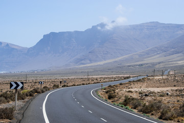 Asphalt road in a desert with mountains