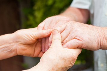 Elderly couple holding hands