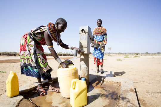 Women from Samburu tribe collecting fresh water from borehole in desert. Kenya, Africa