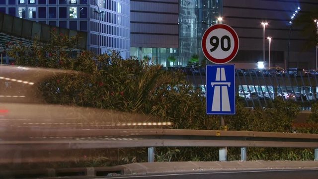 Vehicles passing by a 90 speed limit on a freeway, ramp.