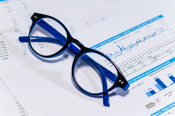 Close up business concept, Glasses on summary report on table office