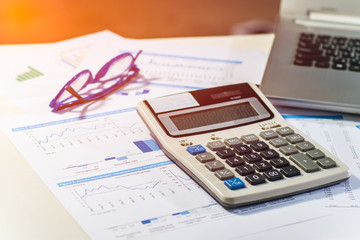Close up business concept, Calculator, glasses and latop on summary report on table office