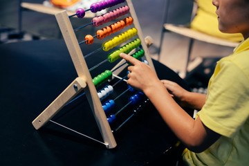Educational colorful wooden abacus beads on table background. School arithmetic symbol, calculating thinking concept, closeup photography