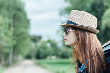 Happy young woman looking out of car window,Toward adventure,relaxing and enjoying road trip.