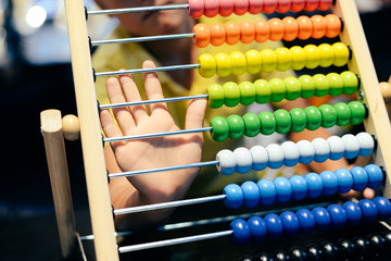 Educational colorful wooden abacus beads on table background. School arithmetic symbol, calculating...