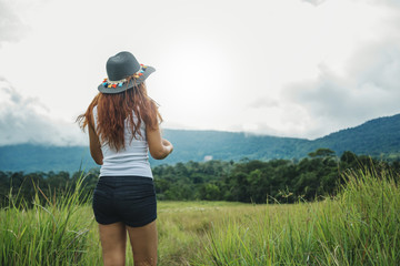 Asian women travel relax in the holiday. on a green pasture.