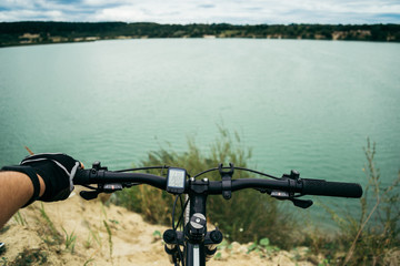 Obraz premium man on bicycle stop near lake and looking the view