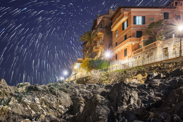 House on the cliff, star trail with comets in the sky..