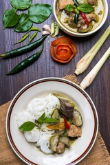 Thai chicken green curry with Thai rice noodles (usually eaten with curries) and old wooden  background, thai food
