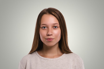 Fototapeta premium Beautiful female looking at camera. Attractive young girl portrait. Healthy woman studio portrait.