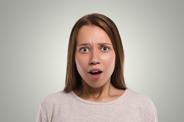 Beautiful  female looking at camera. Shocked girl.  Attractive young girl portrait.  Healthy woman studio portrait.