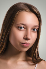 Fototapeta premium Beautiful female looking at camera. Attractive young girl portrait. Healthy woman studio portrait.