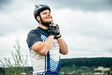 man near standing near lake with bicycle and check helmet