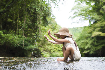 Little girl playing in the mountain stream