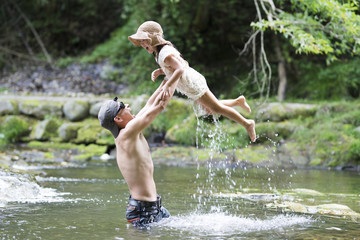 Father and daughter playing on mountain stream