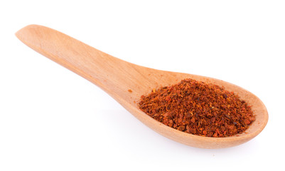 Pile of red paprika powder on spoon wooden
