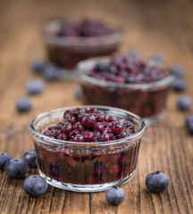 Blueberries (preserved) on wooden background; selective focus