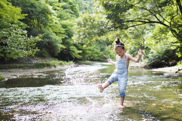 Little girl playing in the mountain stream