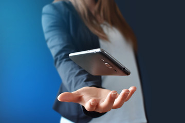 Smartphone floating over female hand. Technology concept