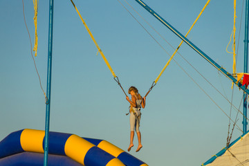 Little girl jumping on bungee trampoline