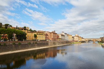 Fototapeta na wymiar Quay of the Arno River and Ponte Vecchio Bridge in Florence, Italy on a summer sunny day 