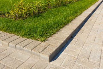 Obraz premium road and lawn divided by a concrete curb