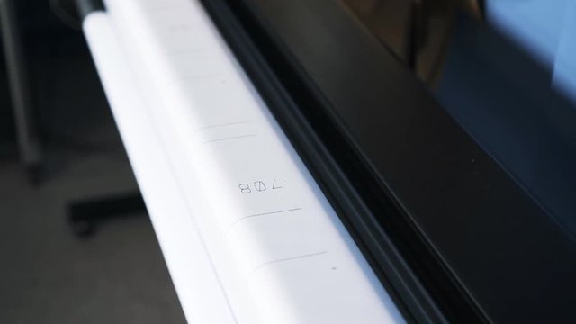 Close up of a plotter printing a blueprint in a print shop or in a company. Concept of complicated equipment. Handheld real time close up shot