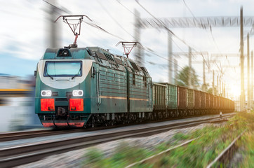 Locomotive electric with a freight train at high speed rides by rail