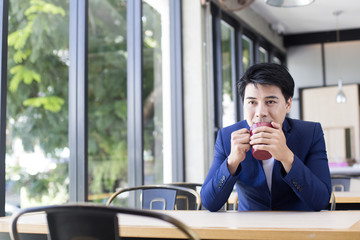 Asian Businessman sitting at Cafe, Man Drinking Hot Coffee at Coffee shop, People Lifestyle Concept.