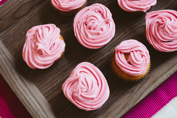 freshly baked muffins cupcakes on a natural wooden board