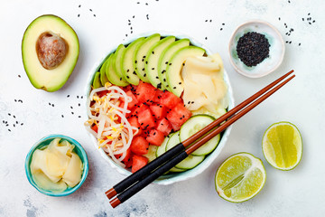 Vegan watermelon poke bowl with avocado, cucumber, mung bean sprouts and pickled ginger. Top view,...