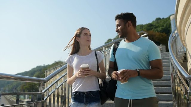 Lovely girl talking with cheerful guy in city environment