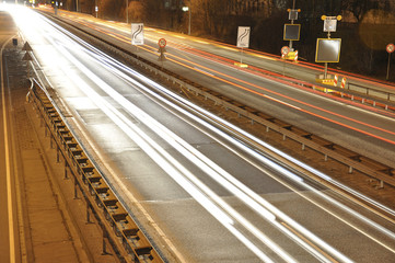 Car lights on german highway construction site with signs at night, long exposure photo of traffic