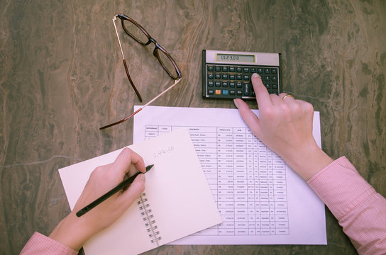 M&atilde;o de mulher trabalhando, calculando finan&ccedil;as, calculadora financeira
