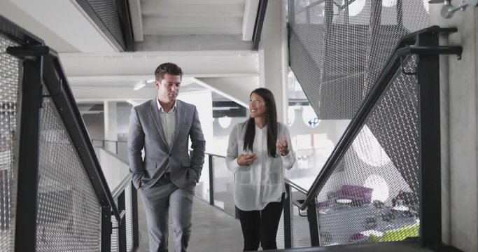 Colleagues walking up staircase in an office talking