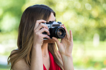 Young woman taking pics outdoor with her camera